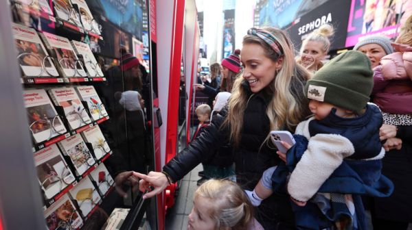 woman and child make a donation at the Giving Machine in Times Square