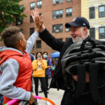 Monsignor Kevin Sullivan helps to distribute backpacks in The Bronx