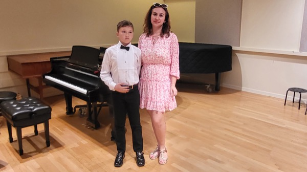 Olha, a Ukrainian refugee supported by Catholic Charities of New York, at her son’s piano recital.