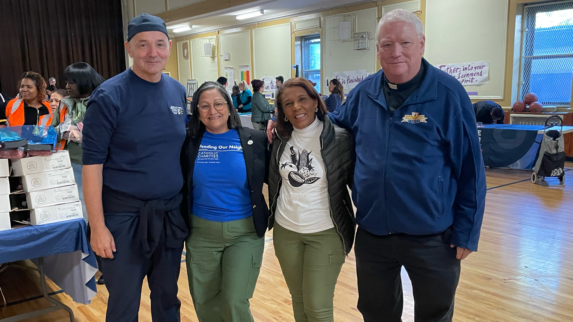Antonio J. Fernández, CEO of Catholic Charities of New York, and Carmen Reyes of Catholic Charities Community Services, pictured with Kenya Taveras and Father Michael of St. Simon Stock–St. Joseph Parish.
