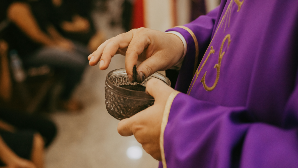 Priest holding an ablution cup with ashes on Ash Wednesday.