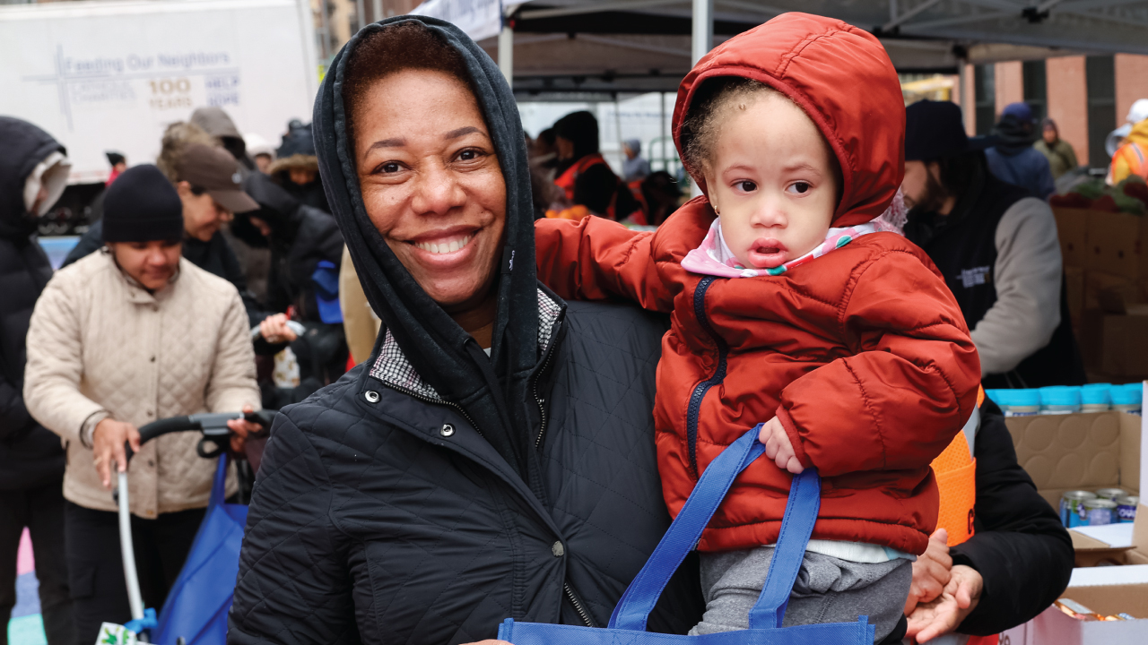 A mother and child at 2026 Holy Thursday Food Distribution event.